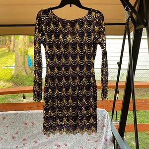 Black dress with gold and purple sequins. Long sleeves.